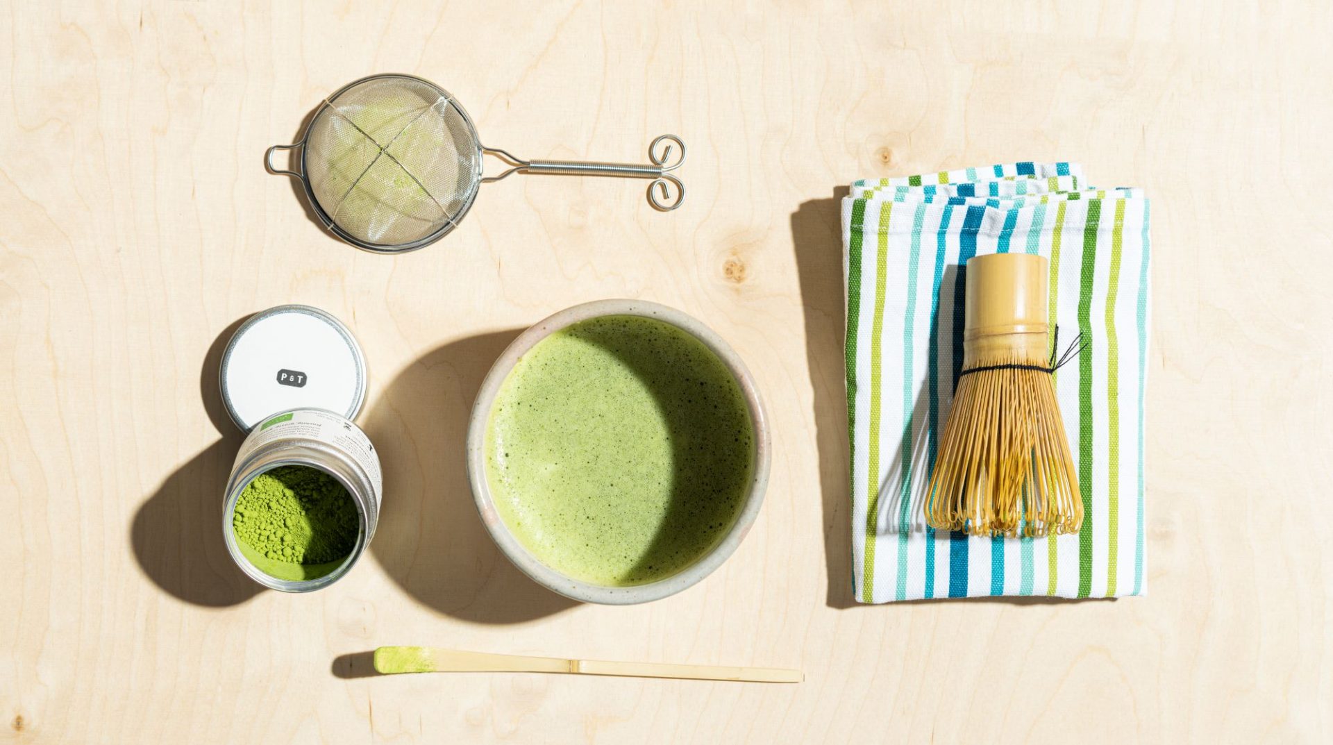 Flat-lay of Japanese tools for brewing matcha tea. Matcha powder